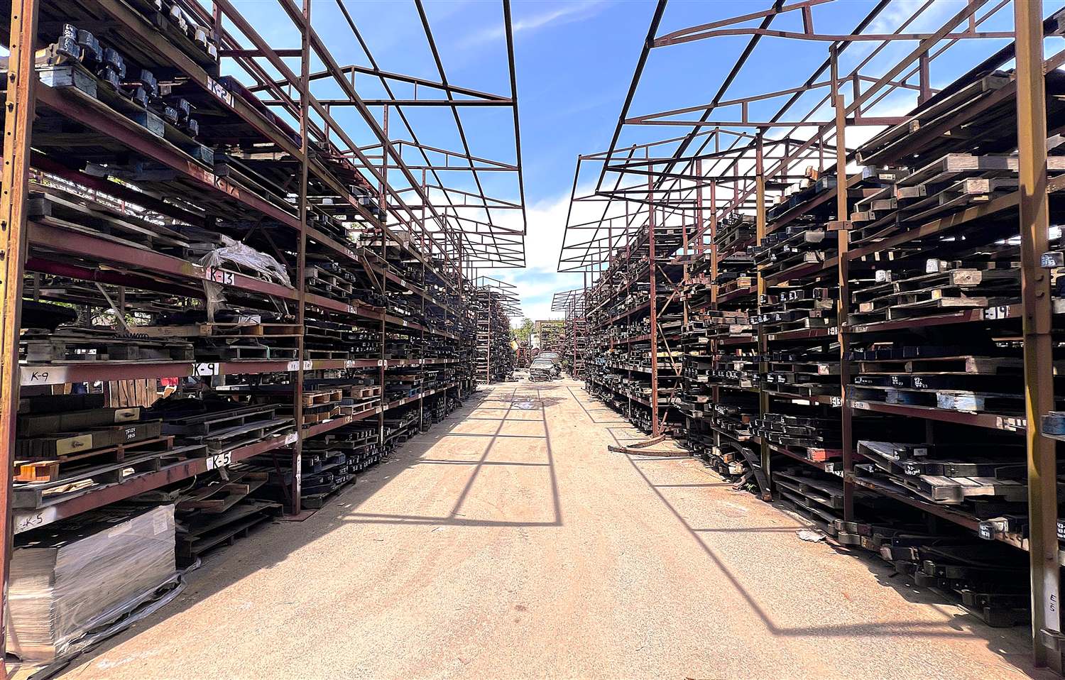 Rows of labeled heavy-duty truck leaf springs and parts stored on steel racks at Palmer Spring Company's Woburn, MA yard