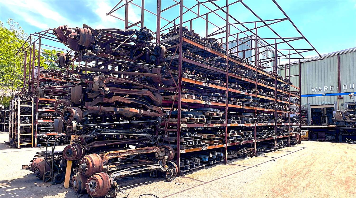 Aged and weathered obsolete heavy-duty truck parts on outdoor storage racks