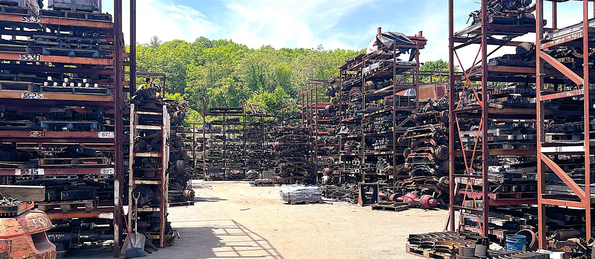 Massive outdoor storage racks of heavy-duty truck axles, springs, and components at Palmer Spring Company