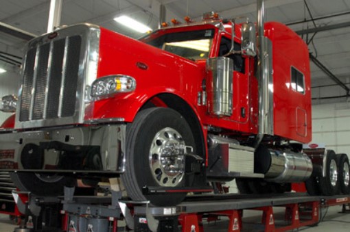 Heavy-duty Peterbilt truck raised on a service lift at Palmer Spring Company