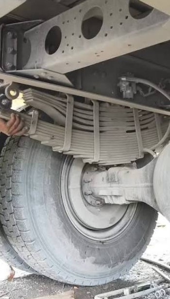 Close-up detail of a heavy-duty truck leaf spring suspension and axle