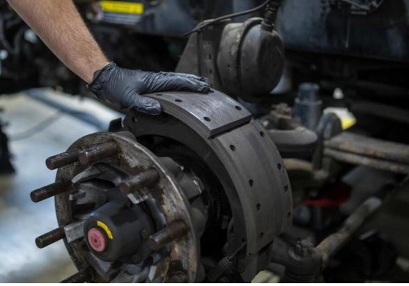 Technician servicing a semi-truck brake system