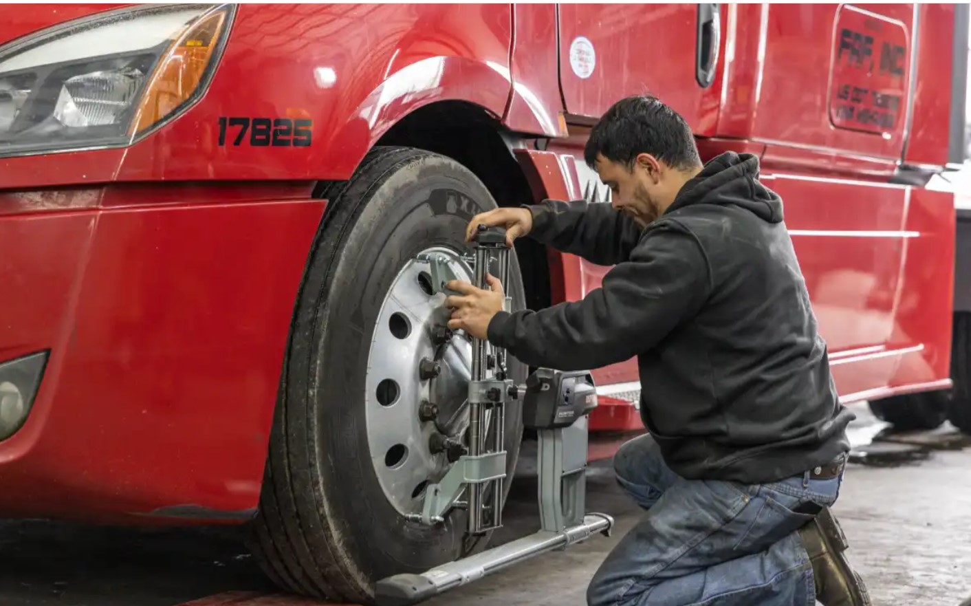 Technician performing a Hunter computerized alignment on a heavy-duty truck wheel